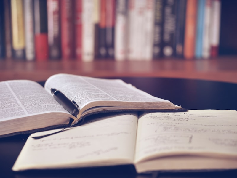 A student studying at a desk surrounded by books