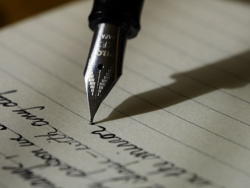 A person writing in a notebook with focused attention